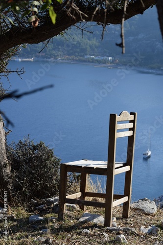 Wooden chair standing in front of a beautiful mountain landscape © Iryna