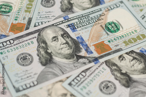 100 Dollars bill and portrait Benjamin Franklin on USA money banknote. Hundred dollar bills on wooden background..