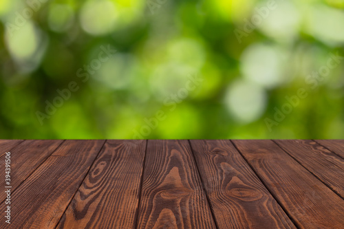 wooden empty table with blurred green garden