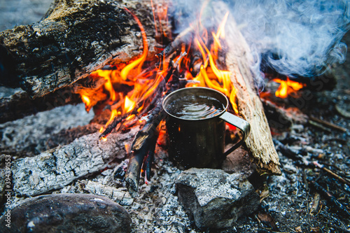 Close up of tea in metal mug heats up on bonfire
