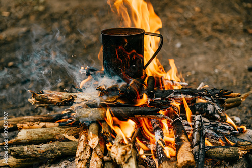 Metal mug heats up on bonfire