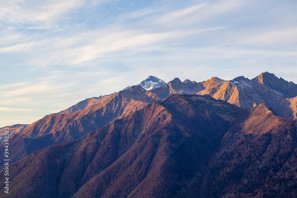Krasnaya Polyana, Sochi, the mountains of the North Caucasus, snow-capped peaks against the background of autumn trees,