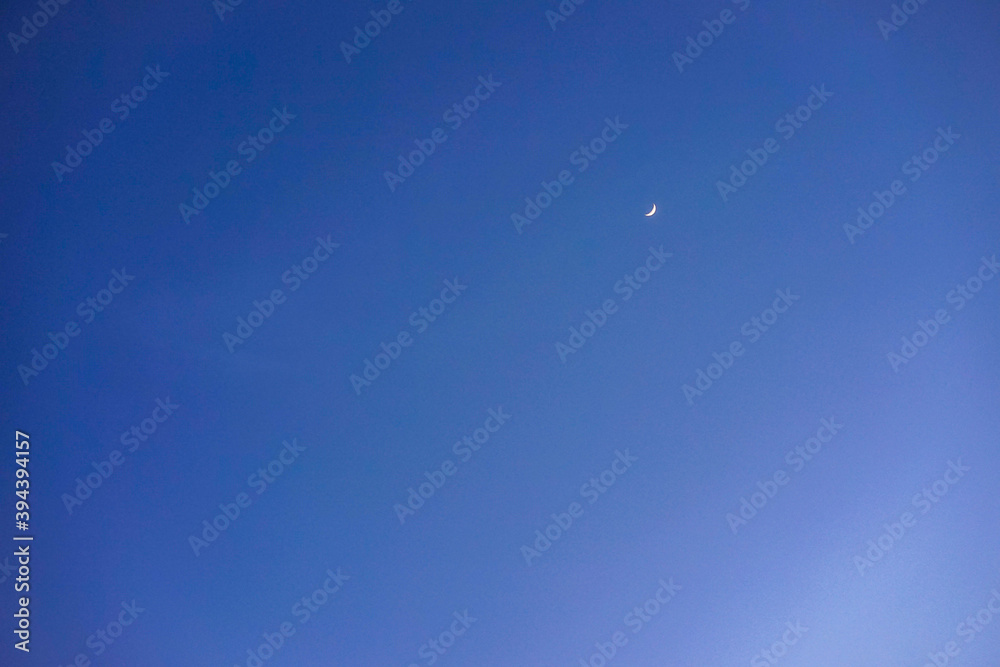 Crescent moon with empty blue sky copy space for banner or wallpaper background Crescent moon with empty blue sky copy space for banner or wallpaper background