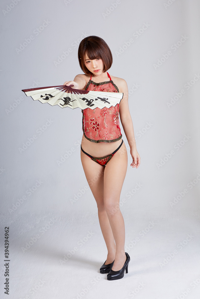 Sexy Chinese girl in bikini dressed, carry a pair of Chinese fans. Dancing sexy acting in