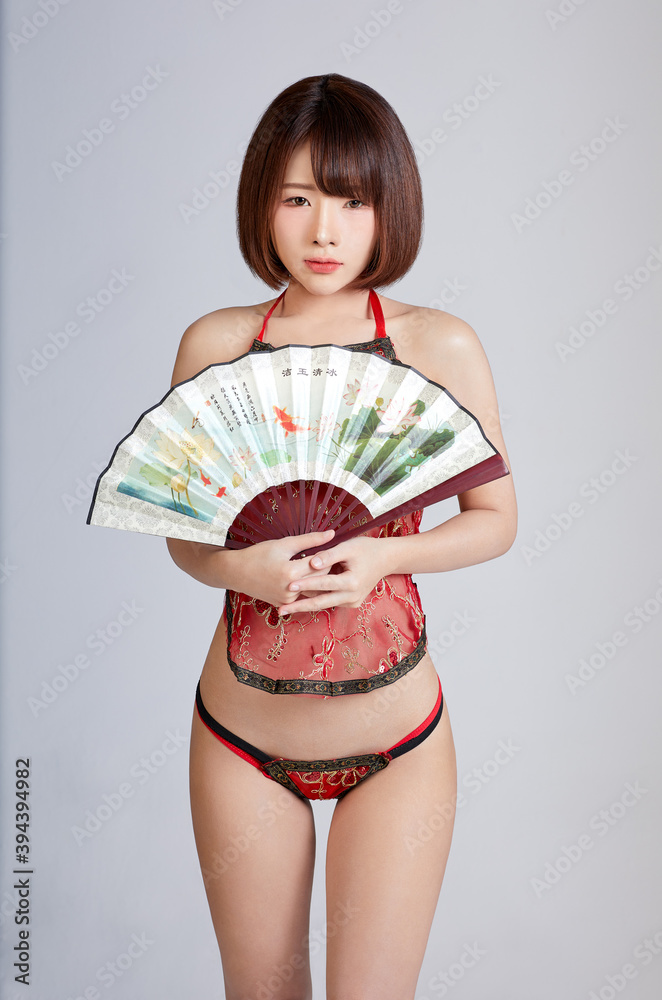 Sexy Chinese girl in bikini dressed, carry a pair of Chinese fans. sexy acting in isolated background. foto de Stock | Adobe Stock