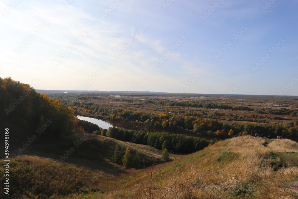 Beautiful autumn panorama, landscape, top view, Vladimir city, Russia. Stunning autumn landscape, top view, sun and blue sky, yellow trees, white Church, Golden domes, green grass, red leaves. Park. 
