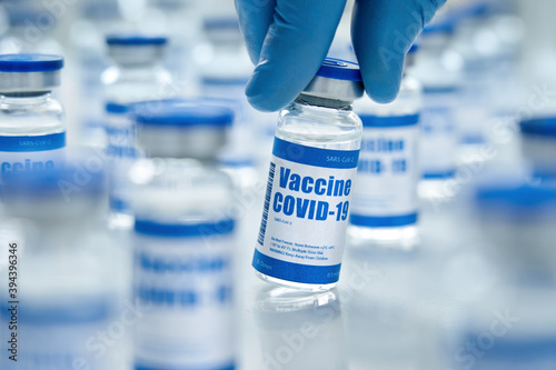 Photography Male doctor hand wears medial glove holding covid 19 corona virus vaccine vial bottle for injection on medical pharmacy background