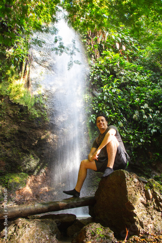Hombre en una cascada de agua natural en la selva