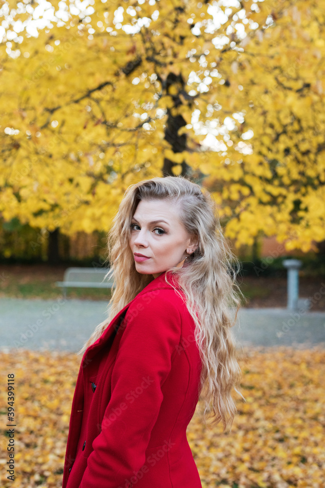 Schöne Frau mit Roten Mantel und Hund im Goldenen Herbst beim Gassi gehn