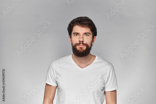 cheerful emotional bearded man gesturing with his hands close-up light background