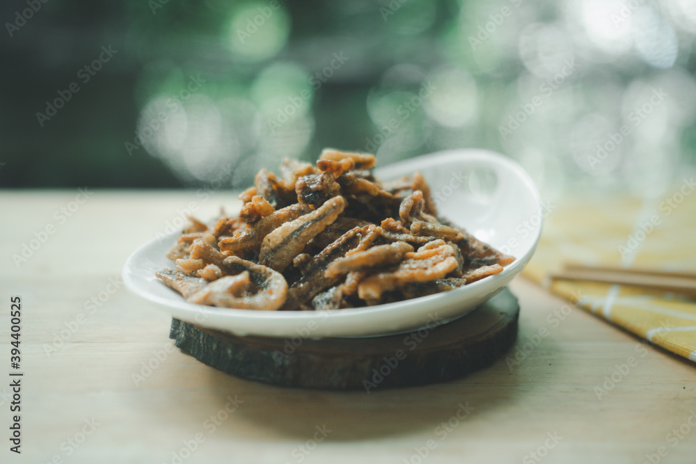 Fried crispy small fish sweet flavored put in ceramics dish with chopsticks. Fried crispy small fish sweet flavored put in ceramics dish with chopsticks.