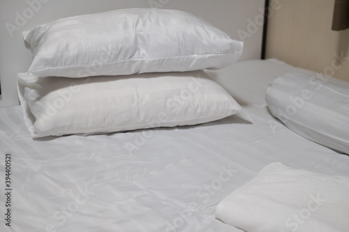 Close-up white bedding sheets and pillow with white towel.