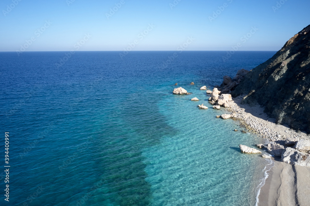 Ocean coastline and horizon with clear blue sky. Tropical ocean and rocky cliffs on seashore. Paradise place for vacation.