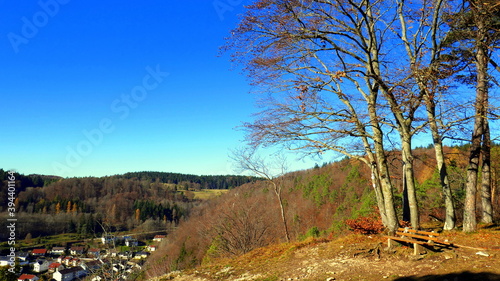 Aussichtsplatz am Traufgang der schwäbischen Alb bei  Albstadt mit Bank und Buchen vor blauem Himmel photo