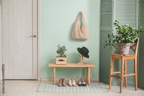 Stylish interior of modern hall with table, houseplants and shoes photo