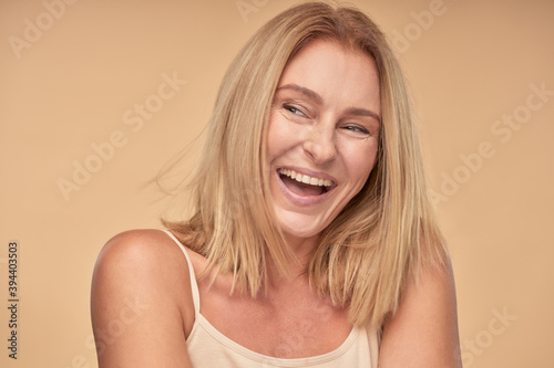 Adult lady in shirt looking away and smiling in studio