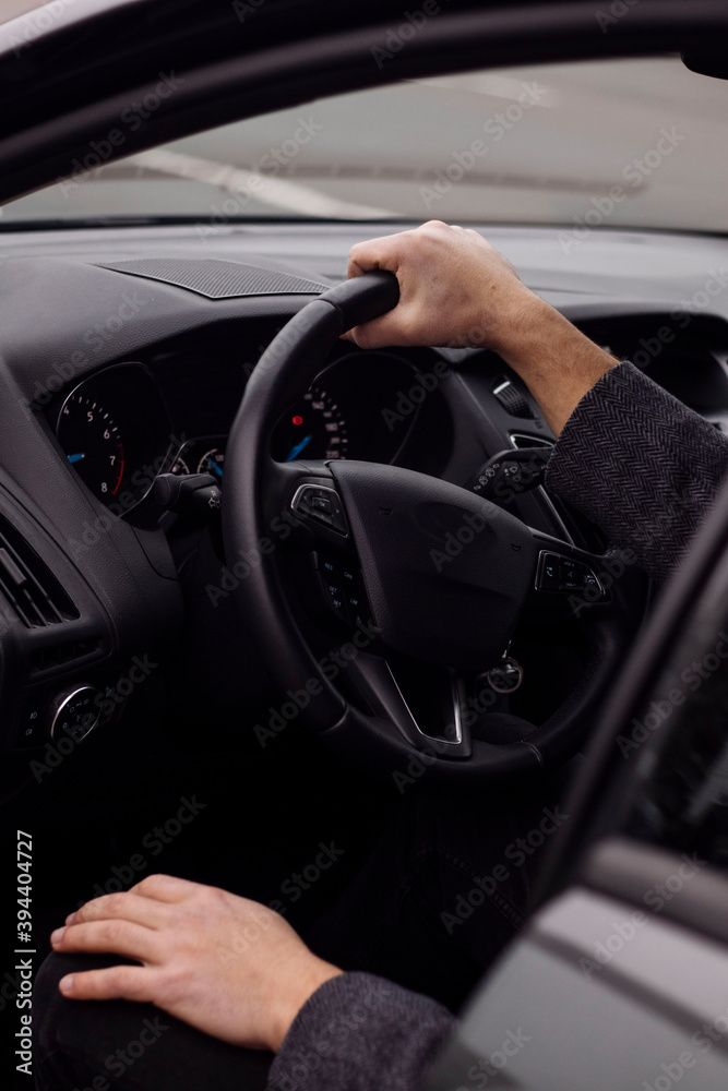 man sitting behind the wheel of a car close up