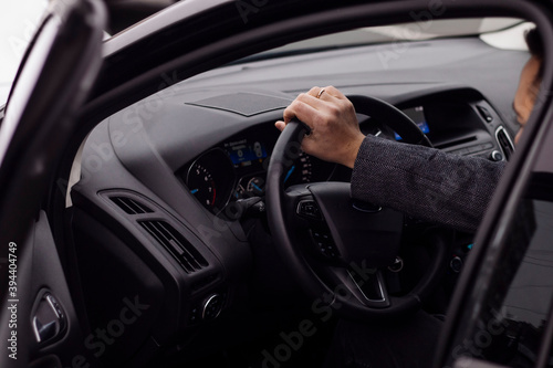 man sitting behind the wheel of a car close up © Екатерина Шелудько