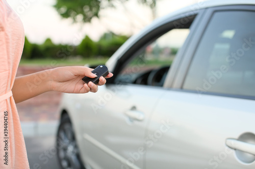 Young woman using car key fob outdoors