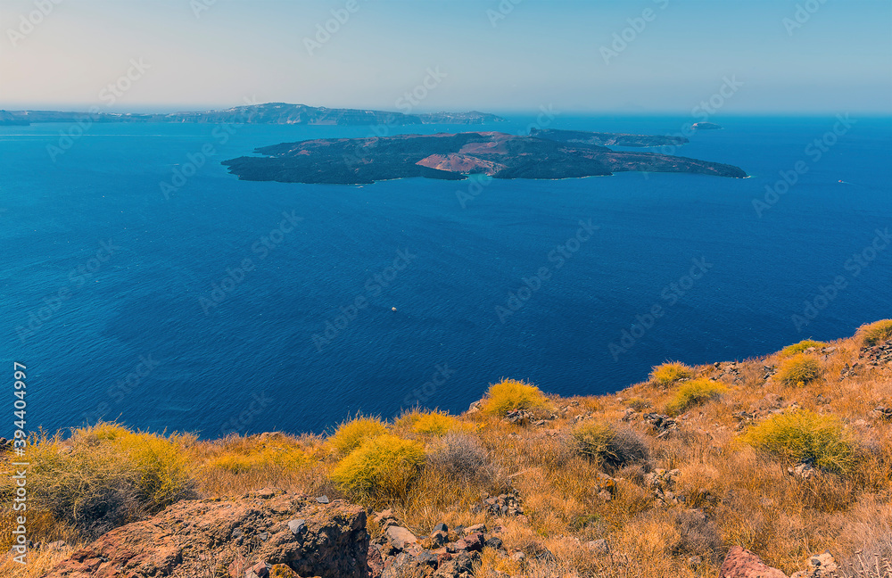 The islands of  Nea Kameni and Palea Kameni in Santorini's caldera viewed from Skaros Rock in summertime