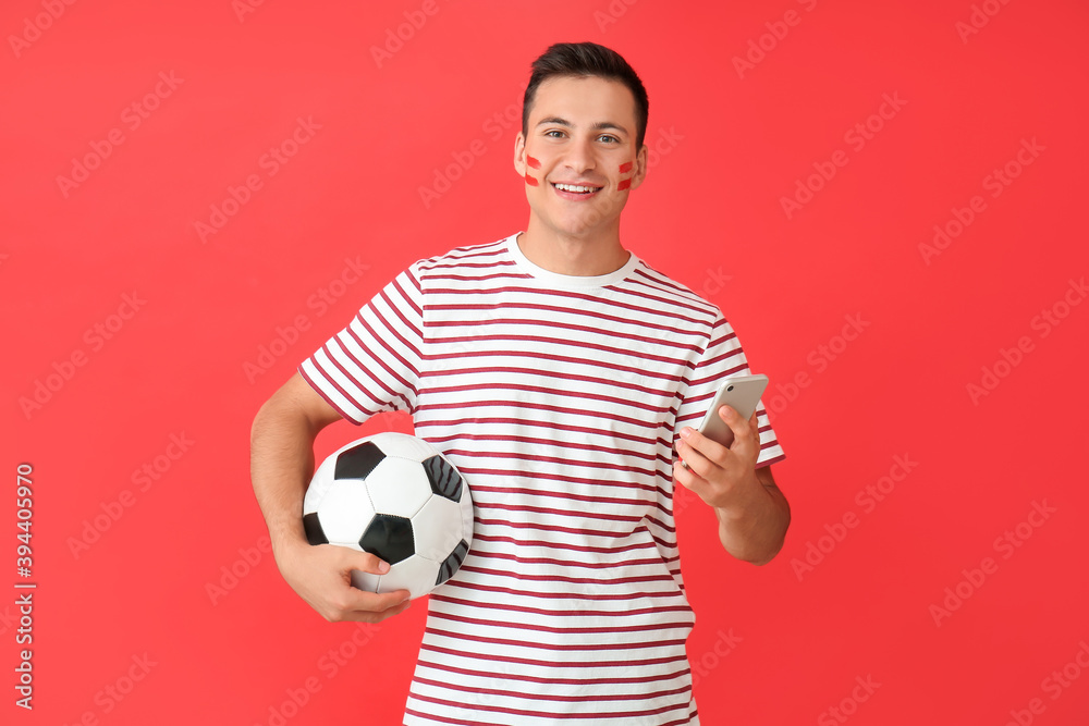 Young man with soccer ball and mobile phone on color background. Concept of sports bet Young man with soccer ball and mobile phone on color background. Concept of sports bet