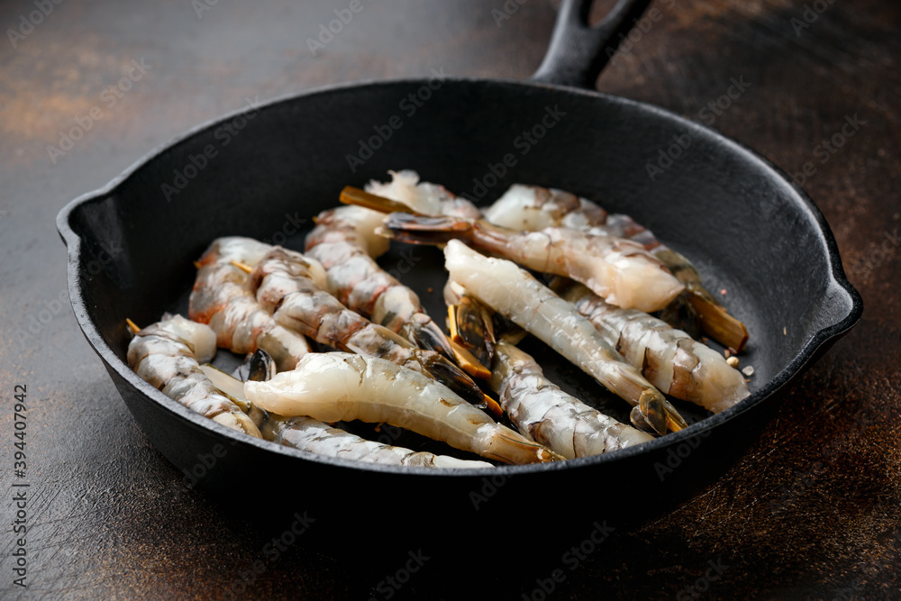 Tiger prawns skewers in iron cast pan, ready to cook. Tiger prawns skewers in iron cast pan, ready to cook.