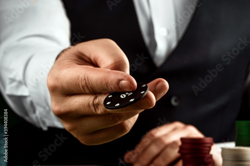 Male hands croupier in a casino and playing chips on a green cloth close-up. Casino concept, gambling, blackjack.