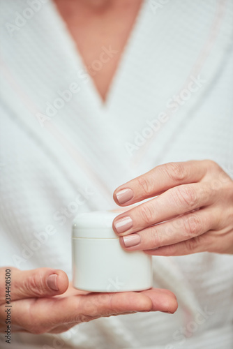 Cream bottle in manicured woman hands