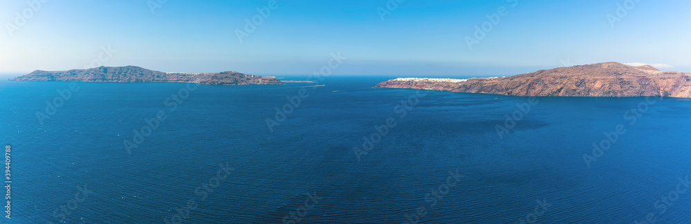 A view towards Thirasia island and the northern rim of the Caldera, Santorini in summertime