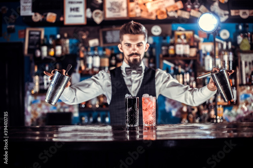 Experienced bartending adds ingredients to a cocktail in the pub