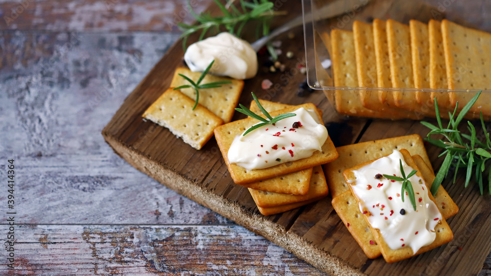 Selective focus. Crackers with cream cheese on a wooden board.