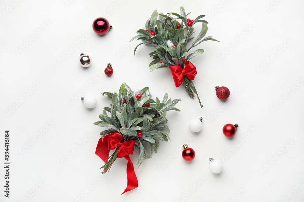 Christmas composition with mistletoe branches and decor on white background Christmas composition with mistletoe branches and decor on white background