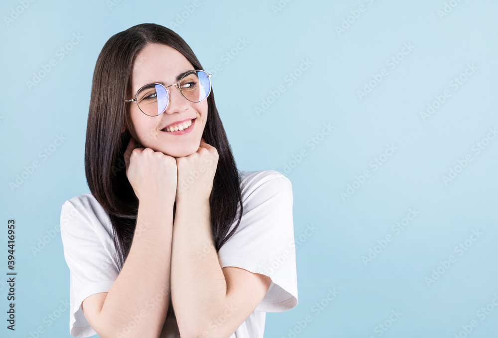 Image of happy young woman posing isolated over blue background, watching to the copyspace in right corner Image of happy young woman posing isolated over blue background, watching to the copyspace in right corner