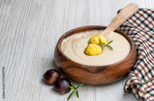 Fototapeta Naklejka Na Ścianę i Meble -  Chestnut cream soup in wooden bowl on white wooden table