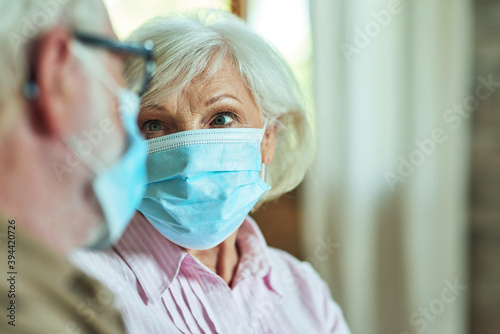 Elderly couple in masks looking each other