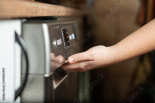 Young woman pushing the buttons on the dishwasher