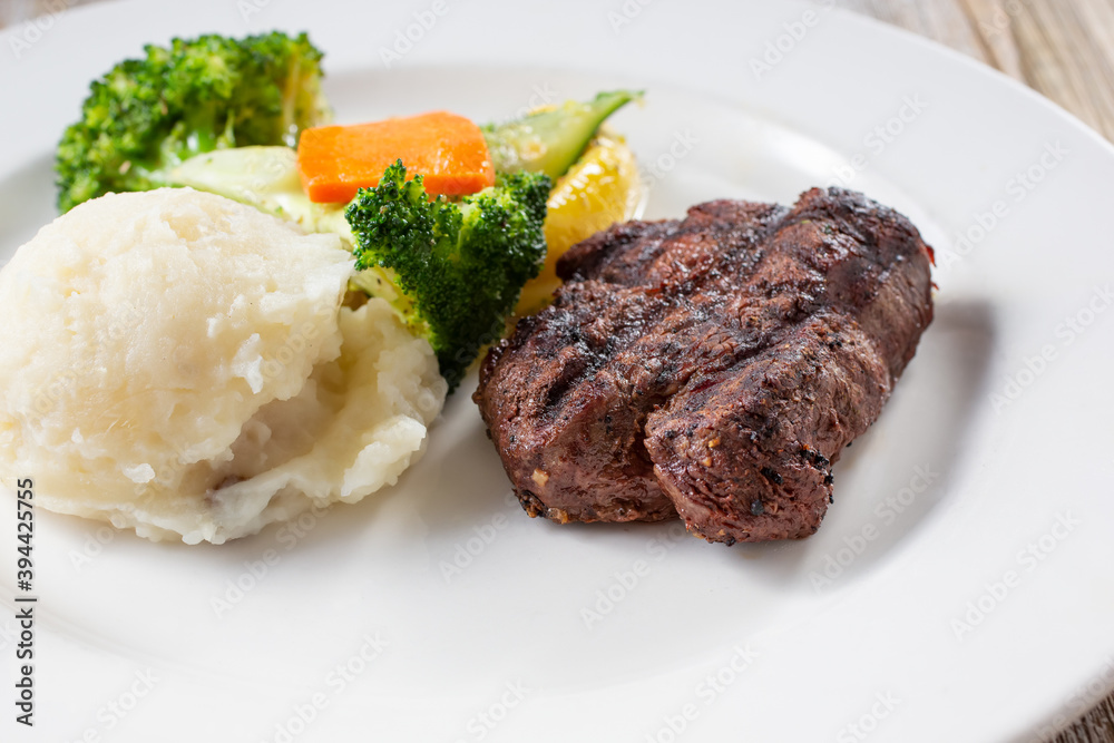 A view of a sirloin steak dinner, in a restaurant or kitchen setting. A view of a sirloin steak dinner, in a restaurant or kitchen setting.