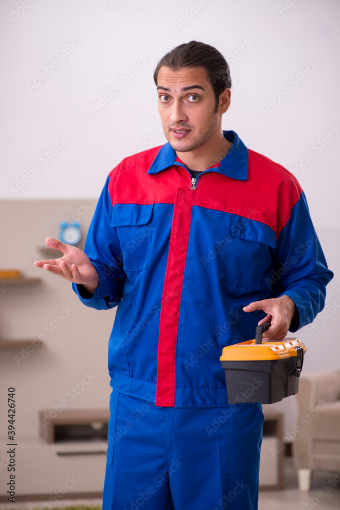 Young male contractor repairing furniture indoors Young male contractor repairing furniture indoors