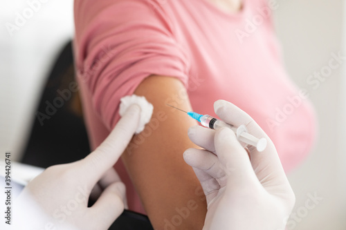 Fototapeta Male doctor doing vaccination to young woman