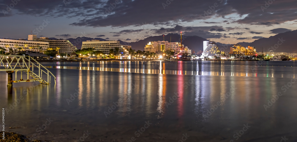 Night on the central public beach in Eilat - famous tourist resort and recreational city in Israel, concept of happy vacation and healthy resting


