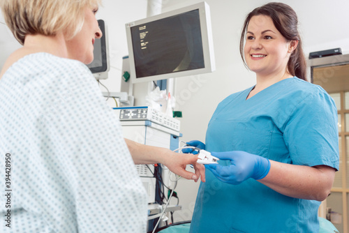 Nurse preparing blood pressure sensor for surgery on patient