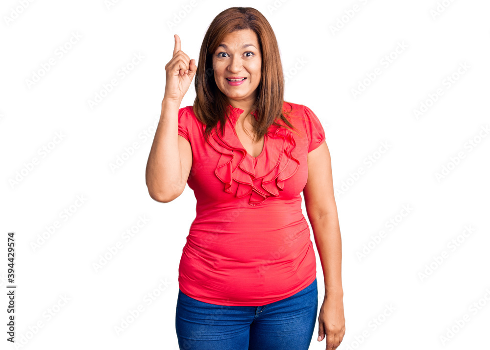 Middle age latin woman wearing casual clothes pointing finger up with successful idea. exited and happy. number one. Middle age latin woman wearing casual clothes pointing finger up with successful idea. exited and happy. number one.