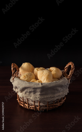 Brazilian cheese bread 'pao de queijo' on basket, homemade cheese buns. typcal snack from minas gerais. Isolated on Dark Background.