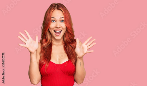Young redhead woman wearing casual clothes celebrating crazy and amazed for success with arms raised and open eyes screaming excited. winner concept