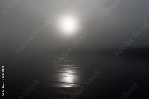 Dark, foggy river early in the morning during sunrise