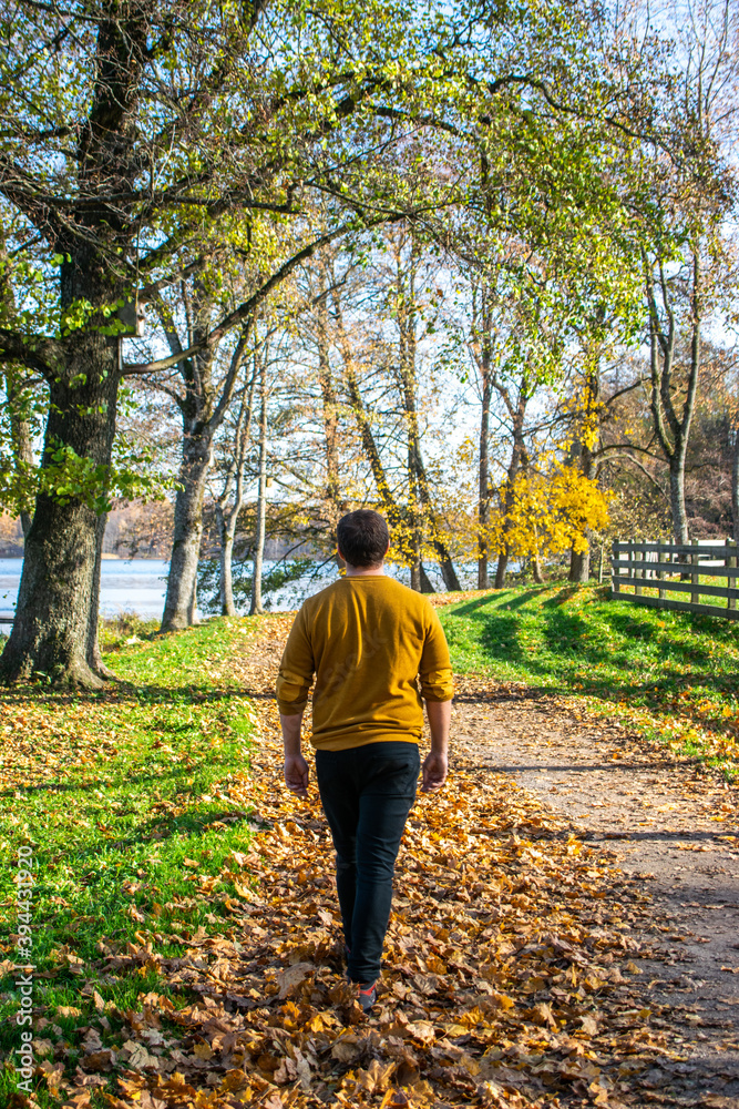 Photo of a young and attractive man walking alone in an abandoned railway during a sunny day Photo of a young and attractive man walking alone in an abandoned railway during a sunny day