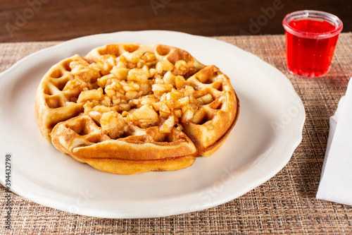 A view of a cinnamon apple Belgian style waffle on a plate.