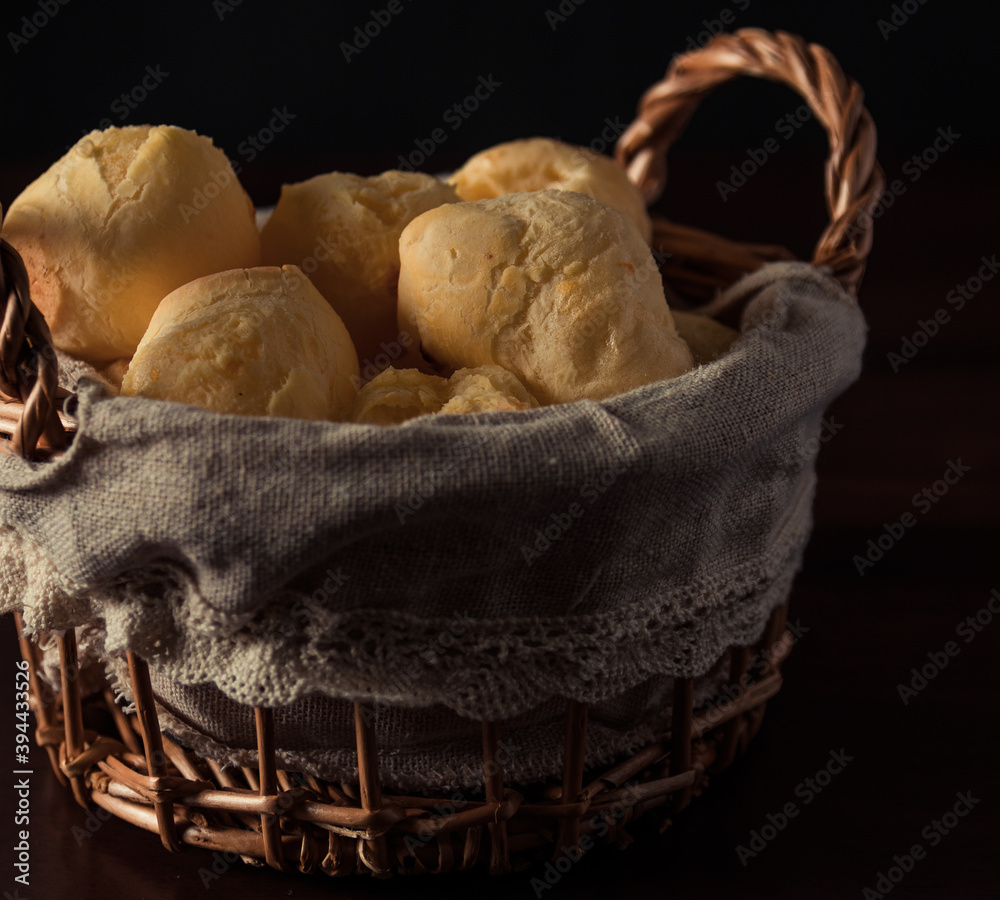 Brazilian cheese bread 'pao de queijo' on basket, homemade cheese buns. typcal snack from minas gerais. Isolated on Dark Background.