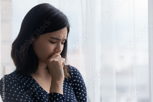 Free Download Close up frustrated Asian young woman standing near window, thinking about personal problems, crying, suffering from break up with boyfriend or divorce, melancholic female lost in thoughts - GFXLoad