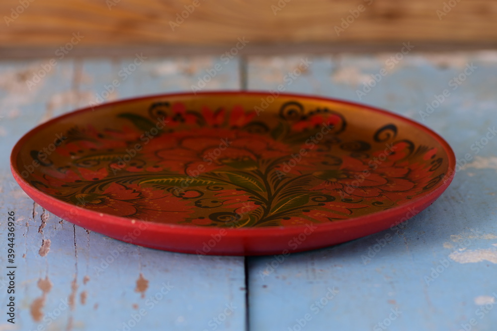 round painted dish on old wooden background